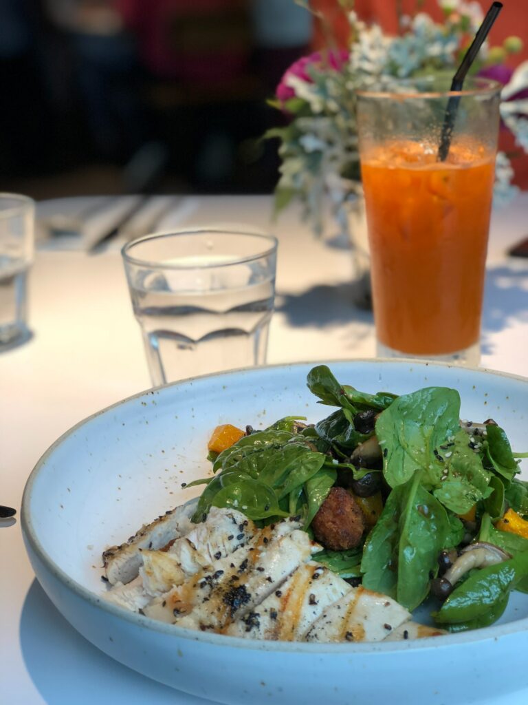 Best Keto Diet Plan - a dinner plate with fish and green vegetables. a drink in the background.