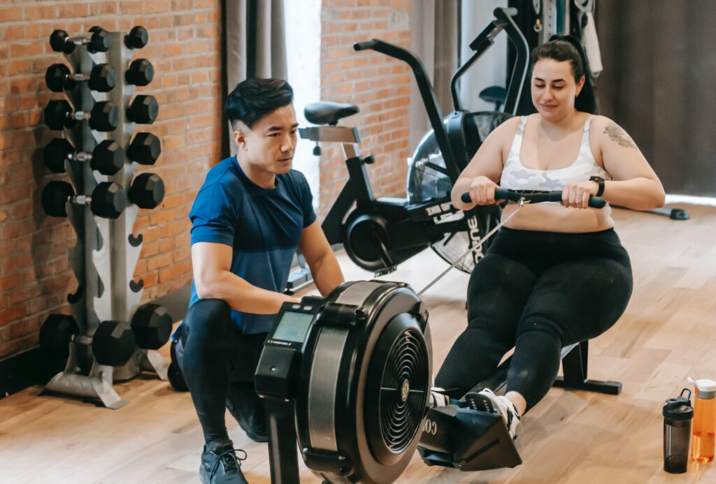 Guy and girl working out on exercise equipment for keto diet