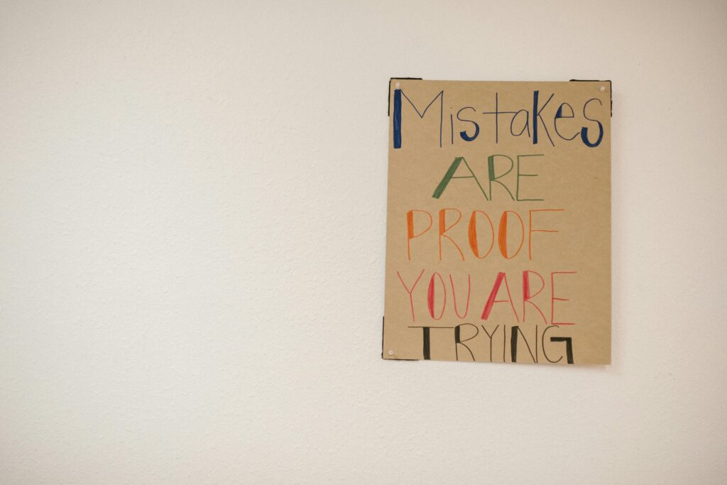 Common Mistakes To Avoid When Starting Keto. A piece of cardboard that says Mistakes are proof you are trying.